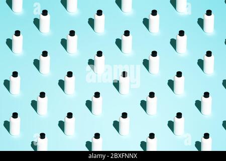 Several containers with black cover for cosmetics without label on turquoise background Stock Photo