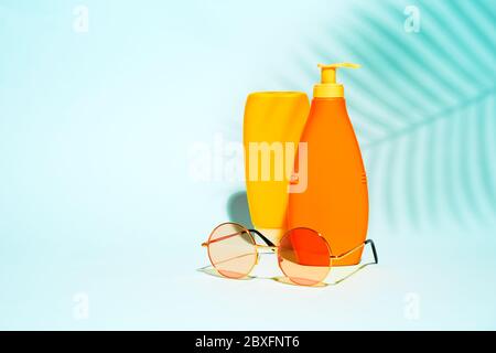 Orange containers without label for lotion, red glasses on blue background Stock Photo