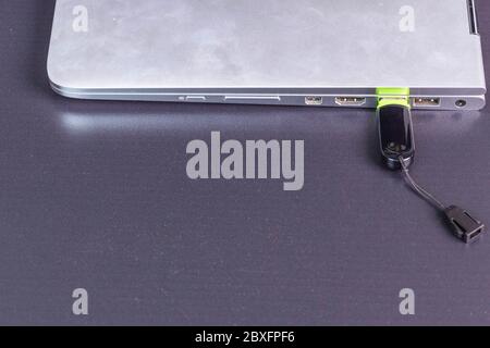 Close up view of  connecting  usb flash drive  to silver notebook computer. Stock Photo