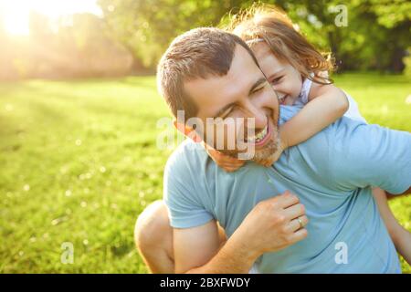 Father's day. Father plays with his daughter in the summer park. Stock Photo