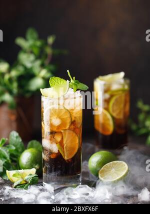 Cuba Libre with brown rum, cola, mint and lime. Cuba Libre or long island iced tea cocktail with strong drinks Stock Photo