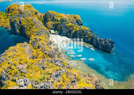 Tourist boats on tour in big and lagoon, aerial view. Tropical landscape. El Nido, Palawan island, Philippines