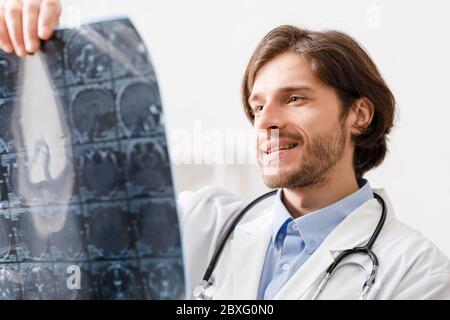 Positive doctor looking at x-ray scans of patient head Stock Photo