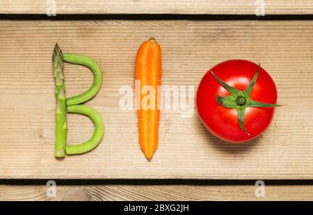 The word "Bio" written with vegetables on rustic wooden background, concept - organic ingredients for healthy vegan food and lifestyle. Stock Photo