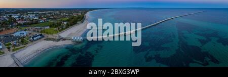 Panoramic aerial dawn view of the iconic Busselton Jetty and the town in the backgreound, which is located 220 km south west of Perth, Western Austral Stock Photo