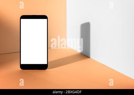 Minimalist modern smartphone mockup for presentation, in perspective front of the corner angle of the peach wall, with overlapping shadows. applicatio Stock Photo