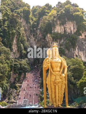 The outside of the Batu Caves in Kuala Lumpur, Malaysia. The huge Lord Murugan hindu deity can be seen. Stock Photo