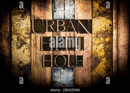 Photo of real authentic typeset letters forming Urban Hell Hole text on vintage textured silver grunge copper and gold background Stock Photo