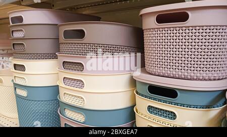 Plastic containers of different colors and prices are placed on a store shelf. Storage of items. Stock Photo