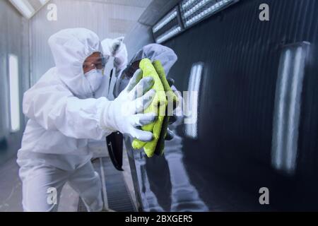 Mechanic in a clean suit polishing a car, Thailand Stock Photo