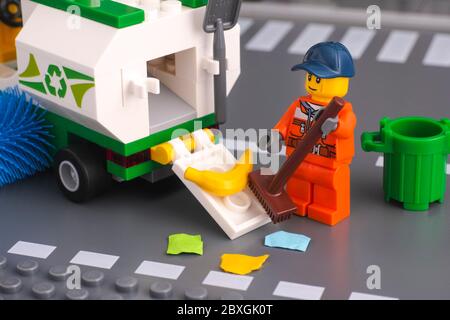 Tambov, Russian Federation - January 17, 2020 Lego cleaner with brush cleaning street and putting garbage in street sweeper truck. Stock Photo