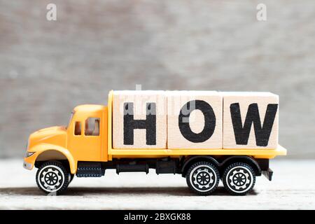 Truck hold letter block in word how on wood background Stock Photo