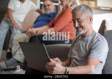 man with a laptop spends a quiet evening in his living room. Stock Photo