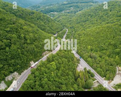 Aerial top down view: of cars driving on zig zag winding mountain road Stock Photo