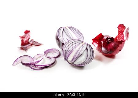 Fresh peeled red onion cut in half and slices isolated with small shadows on a white background, copy space, selected focus, narrow depth of field Stock Photo