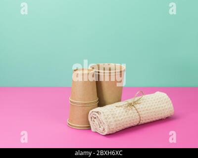 Kitchen accessories from ecological materials. Paper cups and a towel. Stock Photo