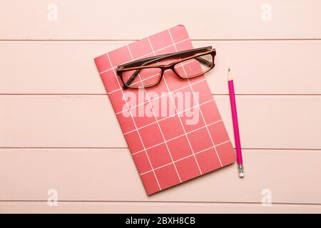 Notebook, pencil and glasses on wooden background Stock Photo