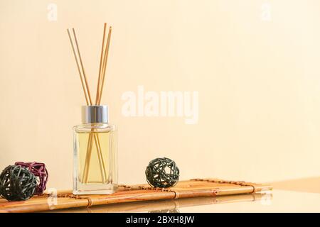 Reed diffuser on table against color background Stock Photo