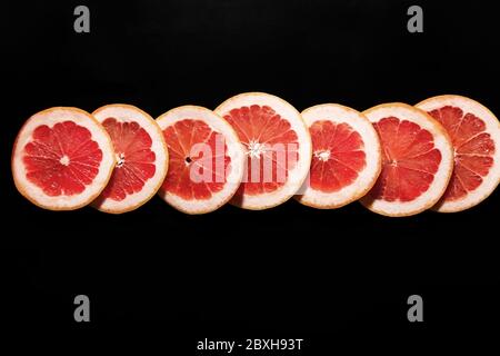 Fresh sliced grapefruit on dark background Stock Photo