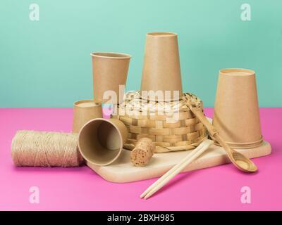 Environmental crockery and other household items from natural materials. Beige pink and turquoise background. Stock Photo