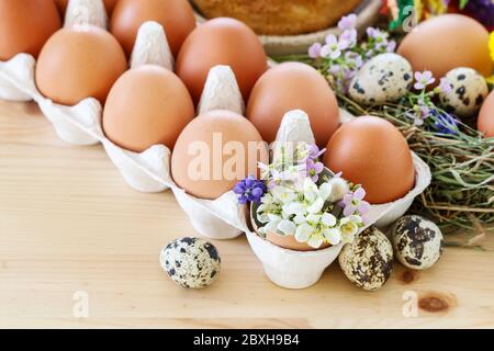 Eggs in paper box and Easter decorations with flowers. Festive time Stock Photo