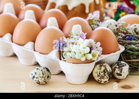 Eggs in paper box and Easter decorations with flowers. Festive time Stock Photo