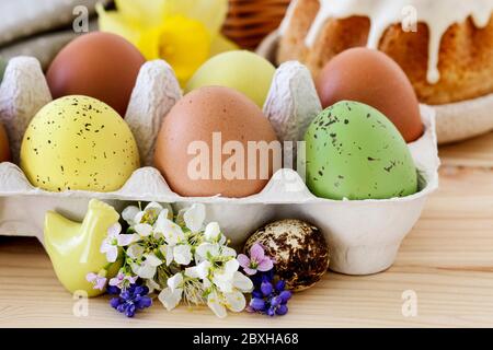 Eggs in paper box and Easter decorations with flowers. Festive time Stock Photo