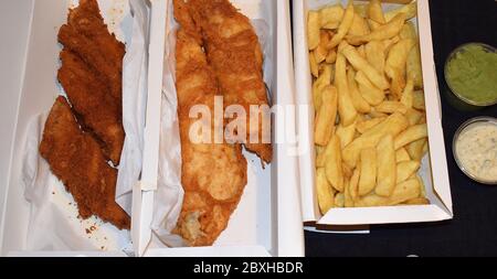 Haddock and rock with chips mushy peas tartare sauce Takeaway seafood traditionally cooked in batter It can also be fried in matzo meal or breadcrumbs Stock Photo