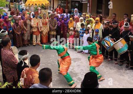 Traditional Silat dance at Minangkabau wedding, in Padang, West Sumatra, Indonesia. Village people dressed in festive clothes, dancers and music orche