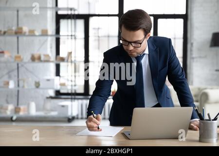 Successful Caucasian businessman busy working on laptop Stock Photo