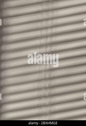 Play of light and shadows, diagonal striped shadows on a white stone wall. Abstact full frame textured background. Stock Photo
