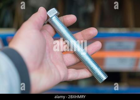 hand holds an iron bolt. repair concept. close-up Stock Photo