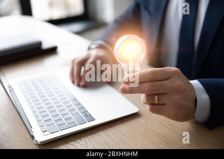 Close up of businessman holding light bulb Stock Photo