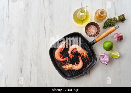 Top view of unpeeled shrimp with head in cast iron skillet Stock Photo