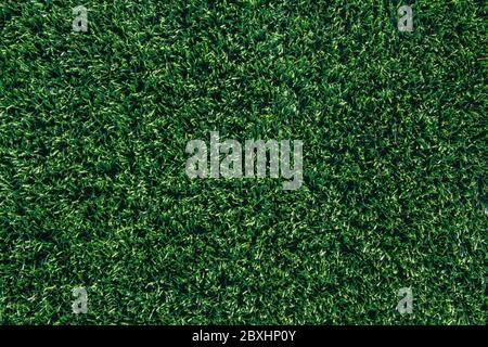 Green grass and white border lines on football ground. Soccer field on artificial turf. Artificial green grass texture. Artificial football field in a Stock Photo