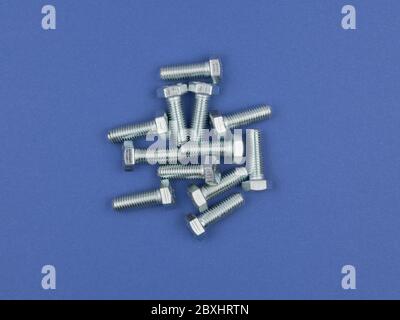 Bolts on blue background close-up. Stock Photo