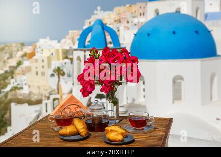 Morning tea and croissants against the backdrop of the architecture of the island of Santorini Stock Photo