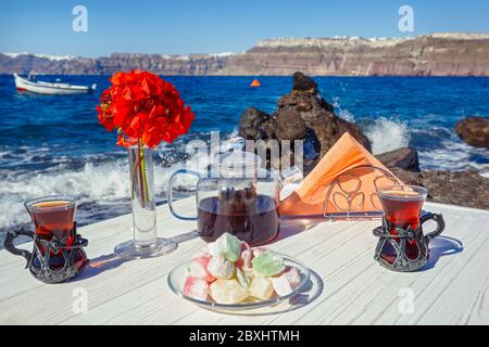 Tea and sweets on the beach against the background of the sea wave Stock Photo