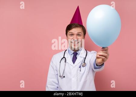 Young caucasian doctor in party holiday is glad with recovery of his patient. Positive facial human emotion. Stock Photo