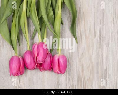 Bouquet of pink tulips on wooden background. Gift for the woman. Stock Photo