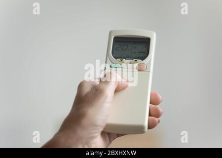 Close up of woman switch AC use remote controller Stock Photo