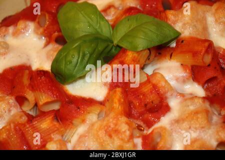 Stuffed baked pasta with tomato, cheese and fresh basil Stock Photo