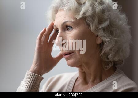 Unhappy elderly woman lost in thoughts in retirement house Stock Photo