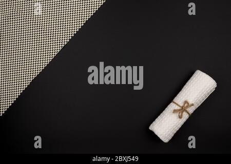 White towel roll and napkin on a black background. Stock Photo
