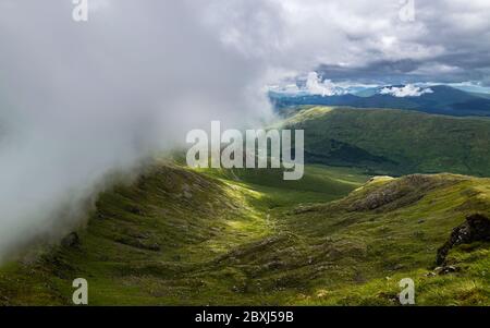 Dramatic summer Scottish Highlands landscape. Low clouds rolling over mountain ridge of Beinn Eunaich, Dalmally, Scotland, United Kingdom. Stock Photo