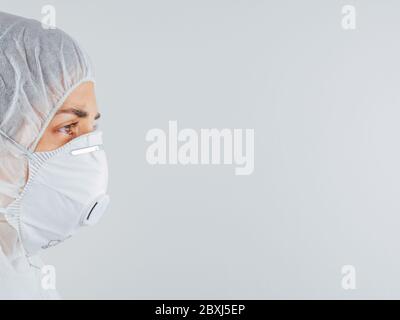 Caucasian doctor. Tired and exhausted scientist or nurse wearing mask and protective suit against biological hazards. Show fear of the situation. Coro Stock Photo