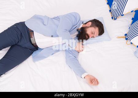 Sleeping in fashionable clothes. Recovery and recharging. Feel tired and sleepy. Sleepy guy in formal clothes sleep bed top view. Lack of sleep. Need more sleep. Evening time. Businessman exhausted. Stock Photo