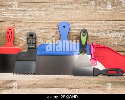 Spatulas for different jobs. Wooden background. Close-up. Stock Photo
