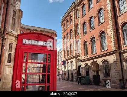 Iconic British Red Telephone Box in Street next to Red Brick Buildings, Nottingham, UK Stock Photo