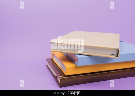 Colored diaries on purple background. Colored notebooks for notes. Stock Photo